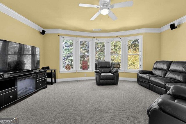 living room featuring carpet floors, ceiling fan, and ornamental molding