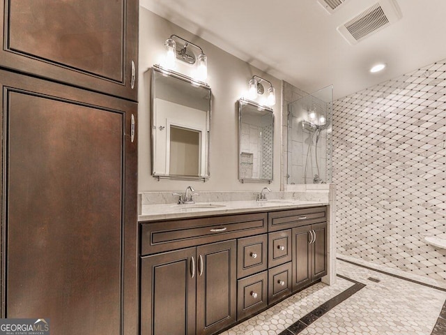 bathroom with tile patterned floors, vanity, and a tile shower