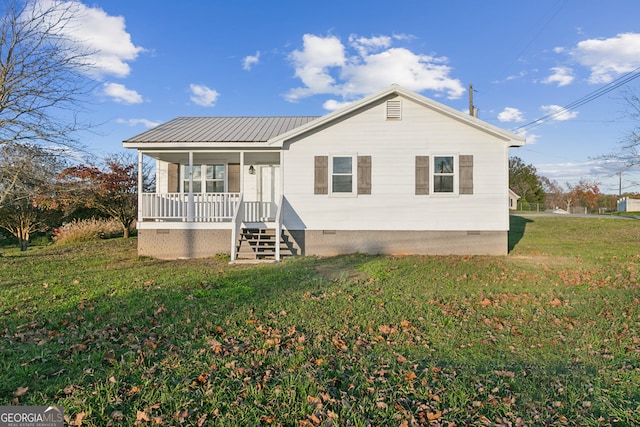 back of house featuring a lawn and covered porch