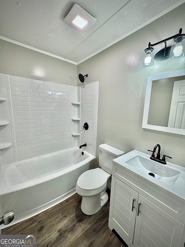 full bathroom with vanity, crown molding, wood-type flooring, toilet, and tiled shower / bath