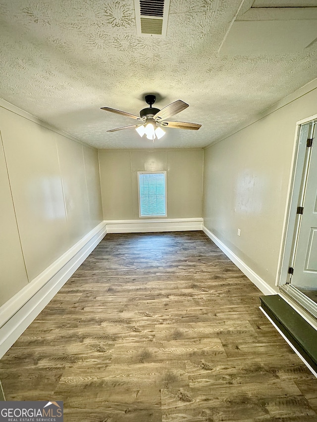 unfurnished room with ceiling fan, hardwood / wood-style floors, and a textured ceiling