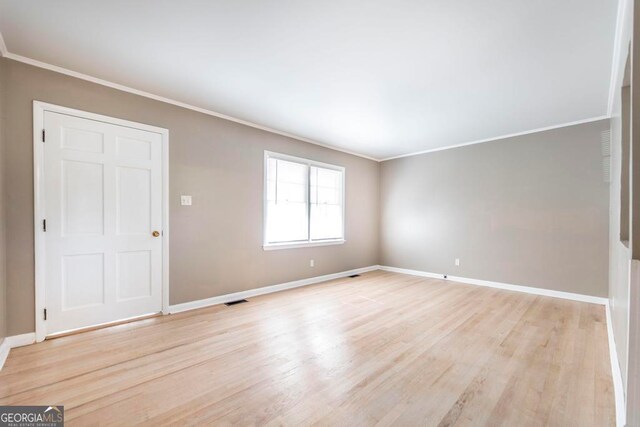 unfurnished room featuring light hardwood / wood-style floors and ornamental molding