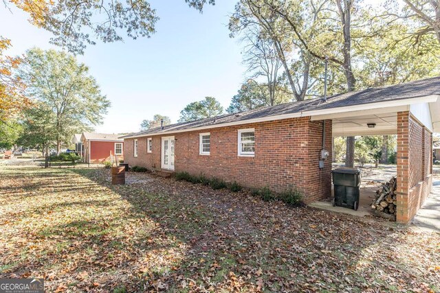 rear view of property with french doors and a yard