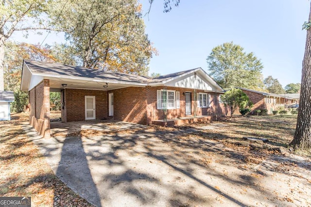 ranch-style house featuring covered porch and a carport