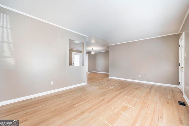 spare room with crown molding and light hardwood / wood-style floors