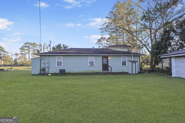 rear view of property featuring a yard and cooling unit