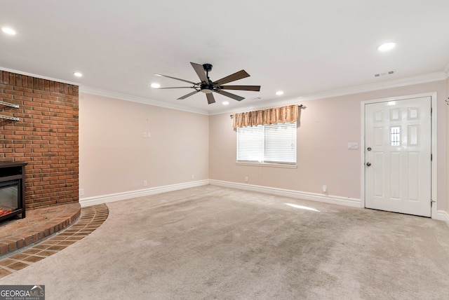 unfurnished living room featuring ceiling fan, a fireplace, carpet floors, and ornamental molding