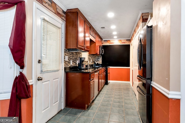 kitchen with decorative backsplash, crown molding, stainless steel appliances, and dark stone counters