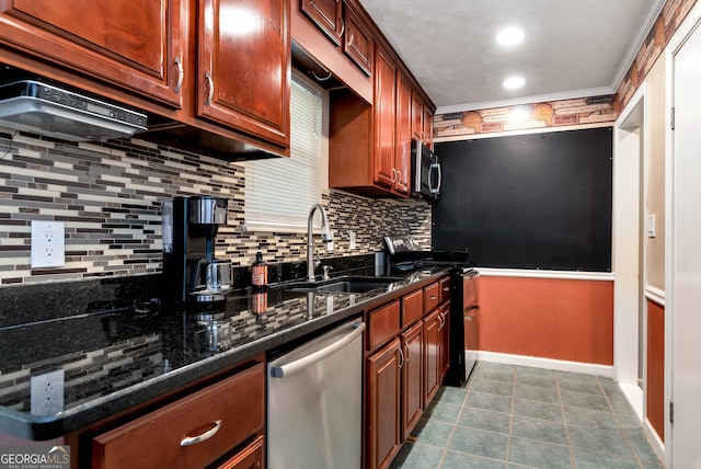 kitchen featuring decorative backsplash, appliances with stainless steel finishes, dark stone counters, and sink