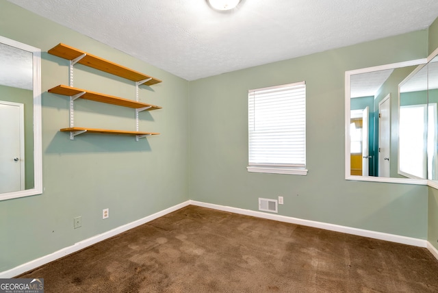 carpeted spare room featuring a textured ceiling