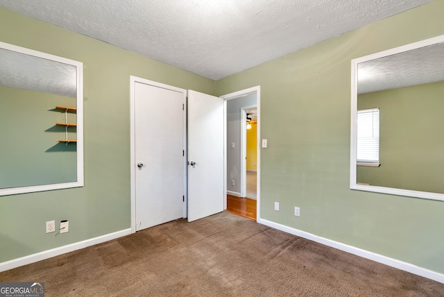 unfurnished bedroom featuring carpet flooring and a textured ceiling