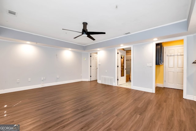 empty room with ceiling fan, dark wood-type flooring, and ornamental molding