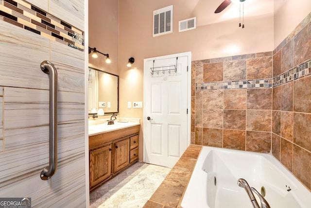 bathroom featuring ceiling fan, a washtub, and vanity