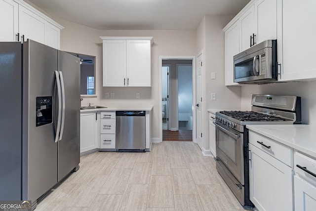 kitchen with ceiling fan, sink, white cabinetry, and stainless steel appliances