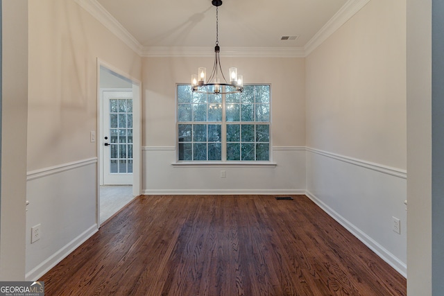 unfurnished dining area featuring a notable chandelier, crown molding, and dark wood-type flooring