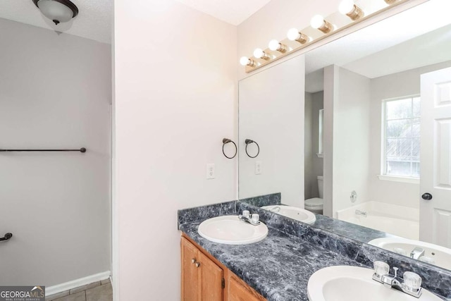 bathroom with a bathtub, tile patterned flooring, vanity, and toilet