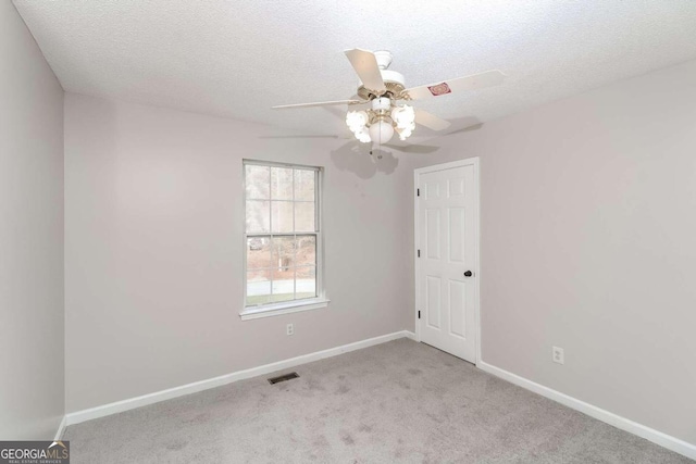 carpeted empty room with ceiling fan and a textured ceiling