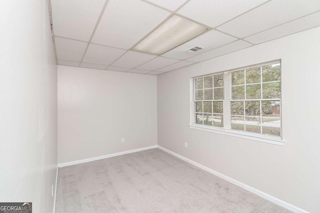 carpeted spare room with a drop ceiling and a healthy amount of sunlight