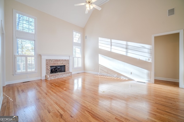 unfurnished living room featuring ceiling fan, a healthy amount of sunlight, light wood-type flooring, and high vaulted ceiling