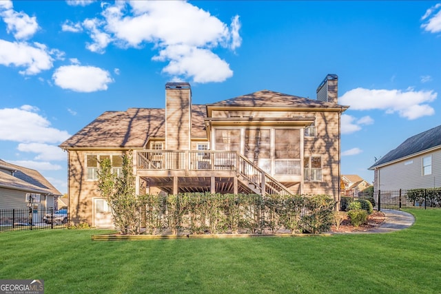 back of house featuring a lawn and a wooden deck