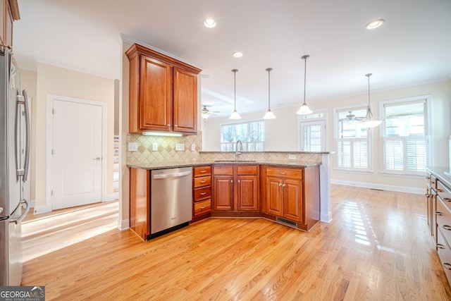 kitchen with ceiling fan, hanging light fixtures, kitchen peninsula, appliances with stainless steel finishes, and light wood-type flooring