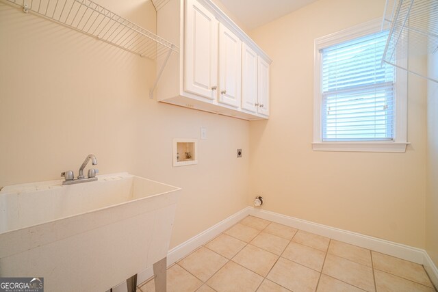 laundry room with electric dryer hookup, cabinets, sink, washer hookup, and light tile patterned floors