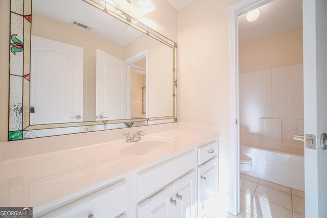 full bathroom featuring toilet, vanity, tile patterned floors, and washtub / shower combination