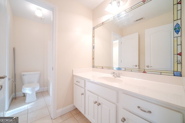 bathroom with toilet, vanity, and tile patterned floors