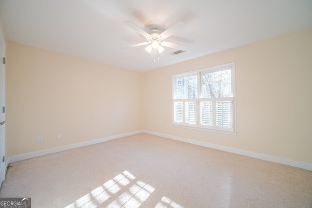 spare room with ceiling fan and light colored carpet