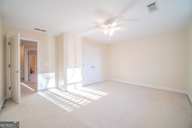 carpeted spare room with ceiling fan