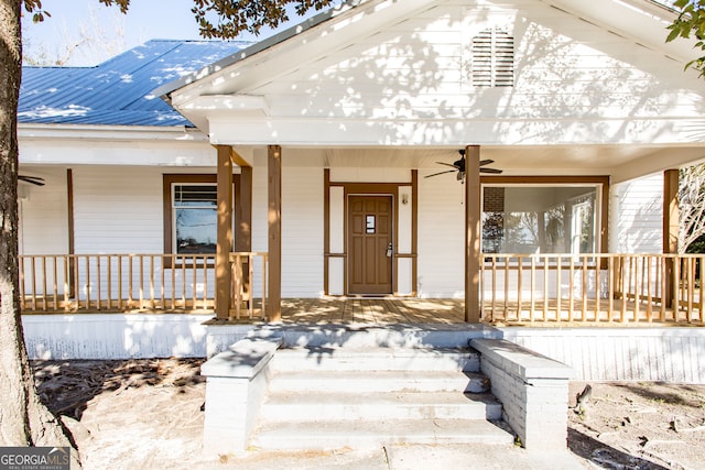 view of exterior entry featuring a porch and ceiling fan