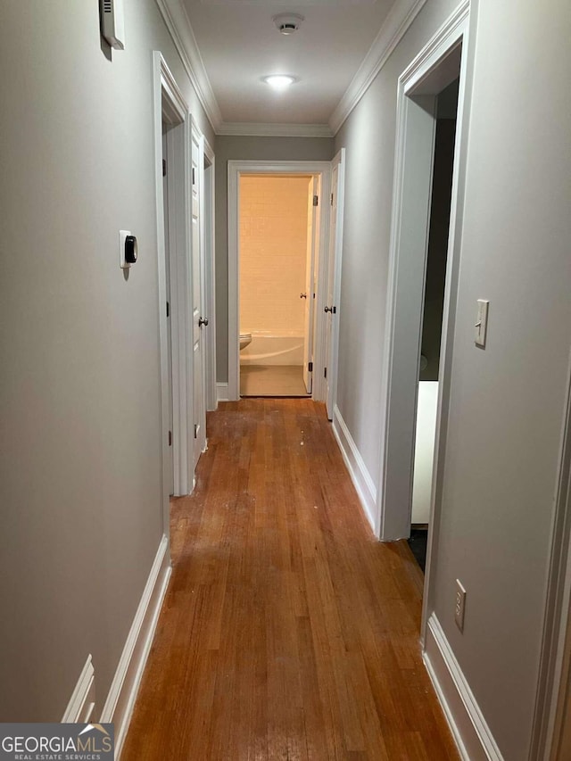 hall with hardwood / wood-style flooring and crown molding