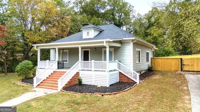 bungalow with covered porch and a front lawn