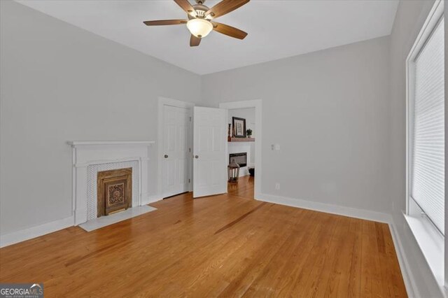 unfurnished living room with hardwood / wood-style floors, plenty of natural light, and ceiling fan