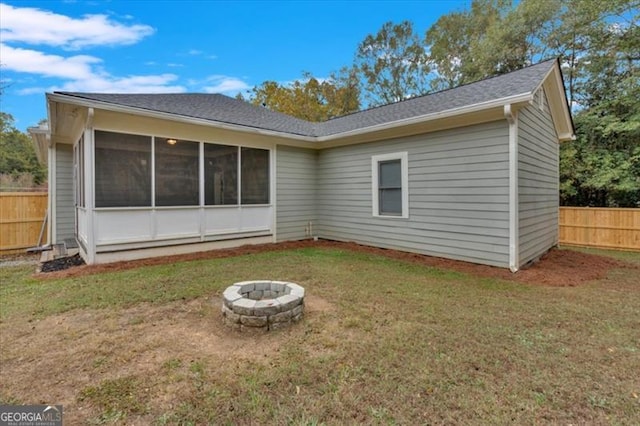 rear view of house featuring a yard and an outdoor fire pit