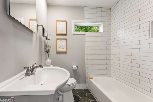 full bathroom with tile patterned floors, toilet, sink, and tiled shower / bath