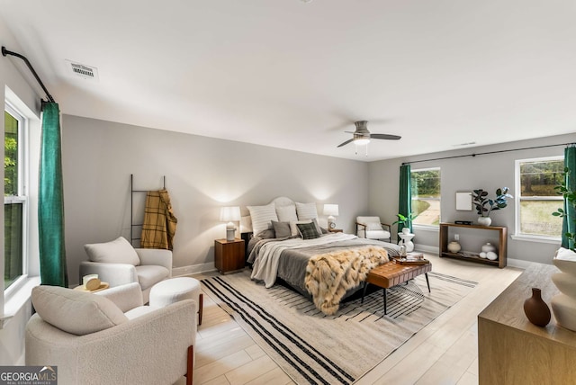 bedroom with multiple windows, ceiling fan, and light hardwood / wood-style flooring