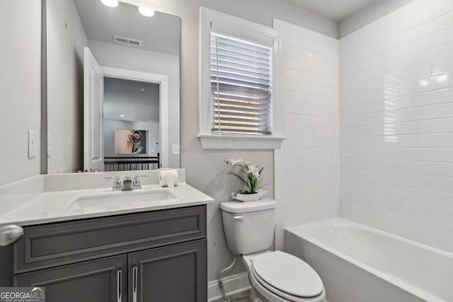 full bathroom with tiled shower / bath, vanity, and toilet