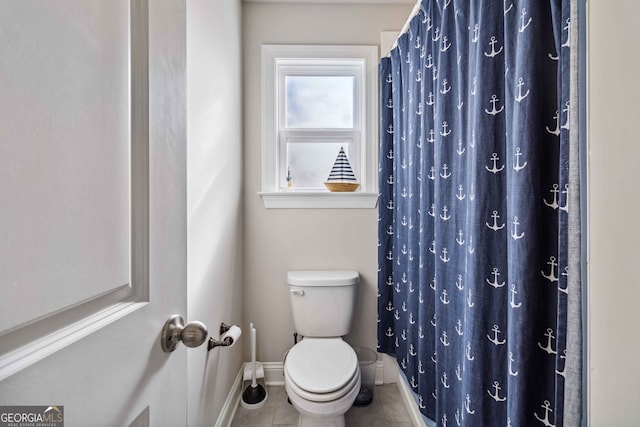 bathroom featuring tile patterned flooring, a shower with curtain, and toilet