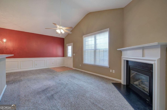 unfurnished living room featuring ceiling fan, dark carpet, and lofted ceiling