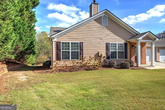 view of side of home featuring a lawn and a garage