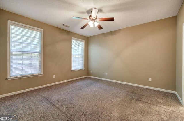 unfurnished room featuring carpet, ceiling fan, and a textured ceiling