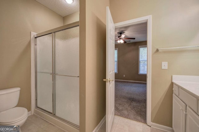 bathroom featuring a shower with door, vanity, a textured ceiling, and toilet