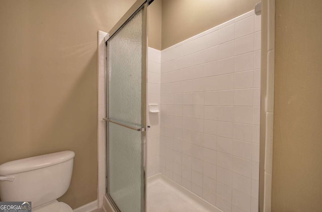 bathroom featuring an enclosed shower and toilet