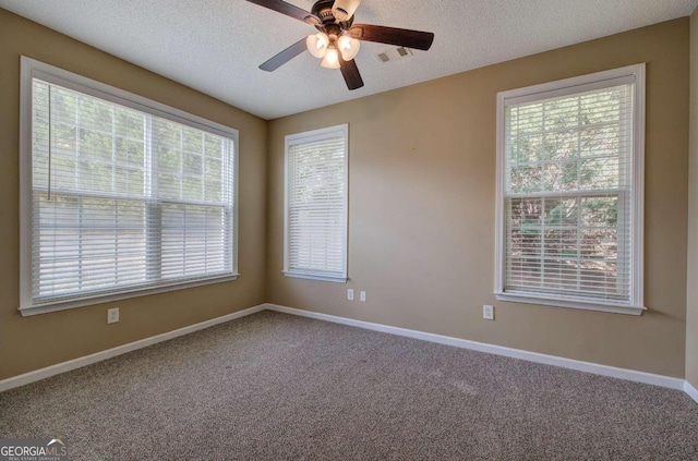 empty room with carpet, a textured ceiling, ceiling fan, and a healthy amount of sunlight