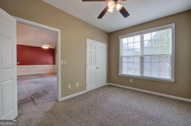 unfurnished bedroom with ceiling fan, a closet, carpet, and a textured ceiling