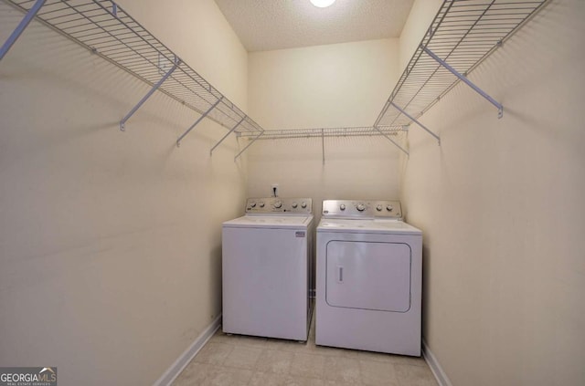 laundry room with washing machine and dryer and a textured ceiling