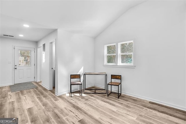 entryway with vaulted ceiling and light hardwood / wood-style flooring