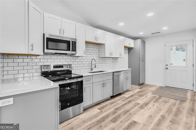 kitchen featuring light hardwood / wood-style floors, sink, white cabinetry, and stainless steel appliances