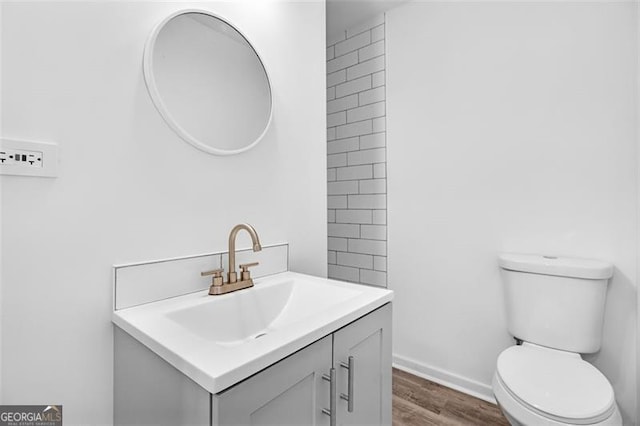 bathroom featuring wood-type flooring, vanity, and toilet